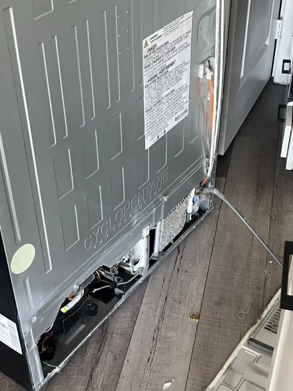 Refrigerator compressor compartment opened for repair